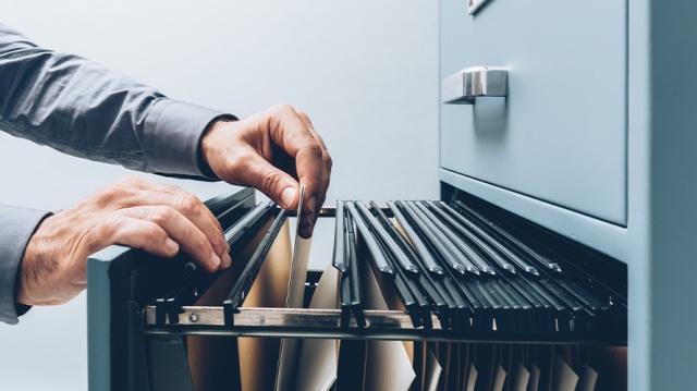 Man pouring through customer data files