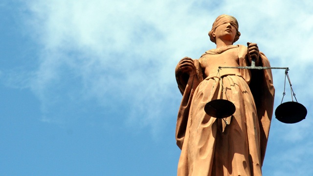 Image of a statue of lady justice against a blue sky background