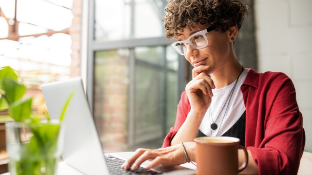 Female confidently working on laptop from home as she looks at insights for providing client and accounting advisory services