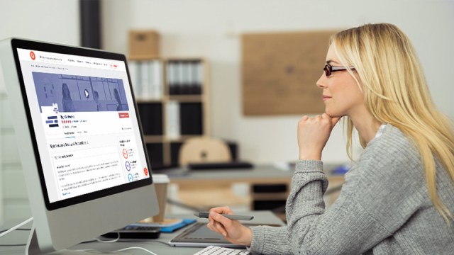 A female with long blonde hair and glasses sits in front of a computer monitor looking at the screen while her chin rests on her left hand. She is smiling as she examines how Rightworks meets her QuickBooks hosting needs.