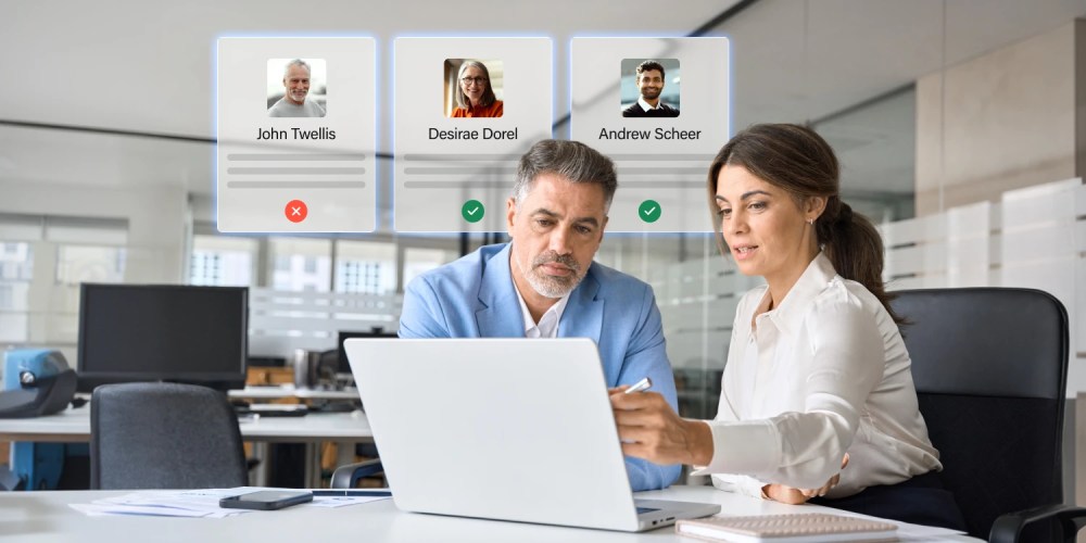 man and woman looking at computer screen talking about compliance