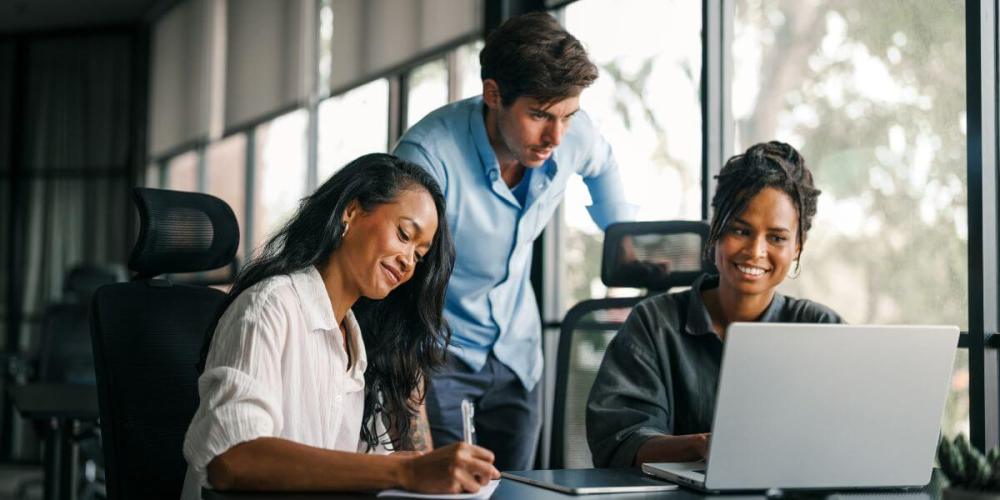Image of coworkers in front of a computer screen
