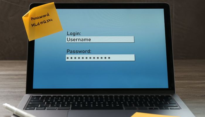 Computer screen with the password written on a post-it note.