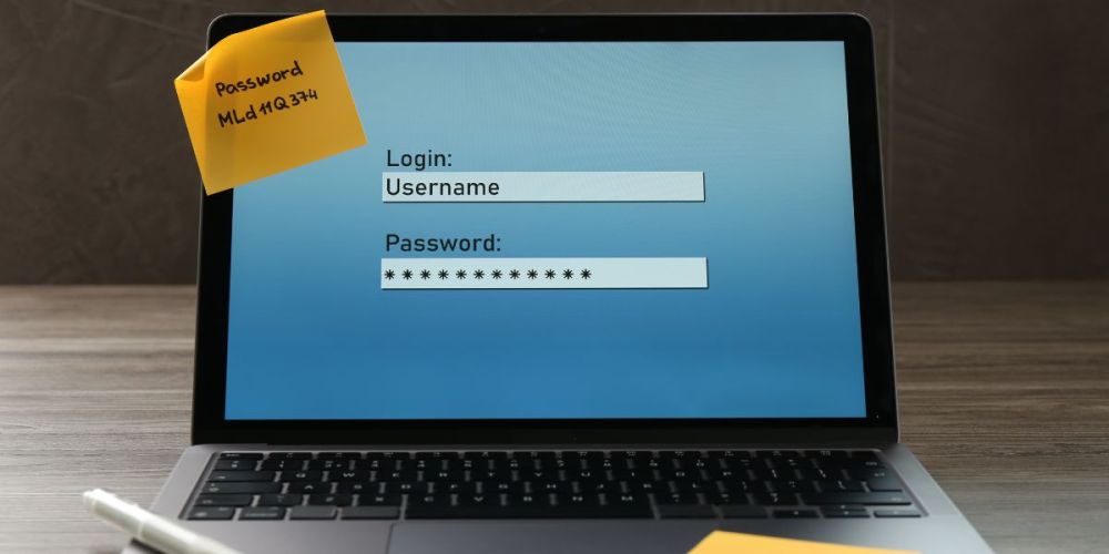 Computer screen with the password written on a post-it note.